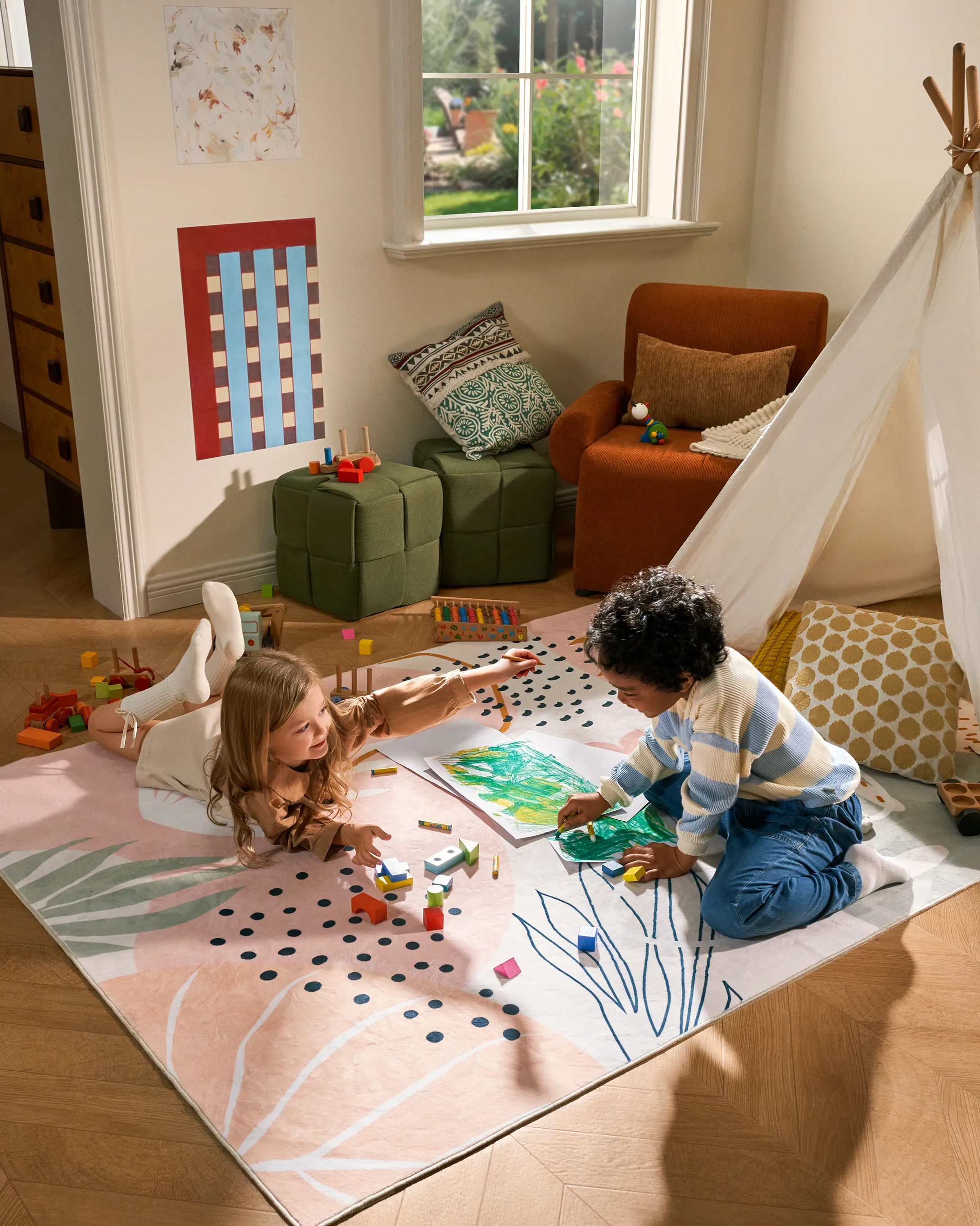Children playing on a colorful rug in a room with a teepee and furniture.