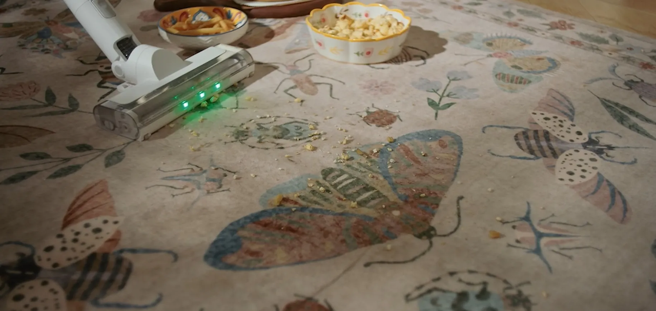 Vacuuming crumbs from a patterned area rug during spring cleaning