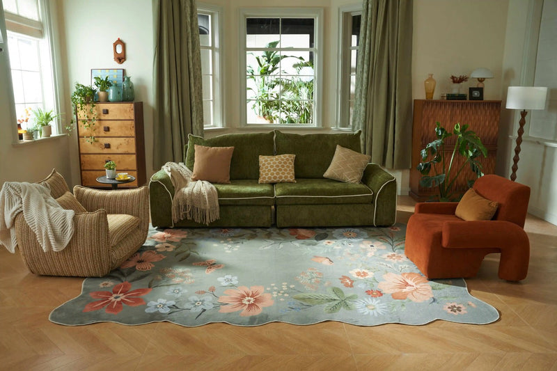 Green velvet sofa with floral area rug in warm vintage living room